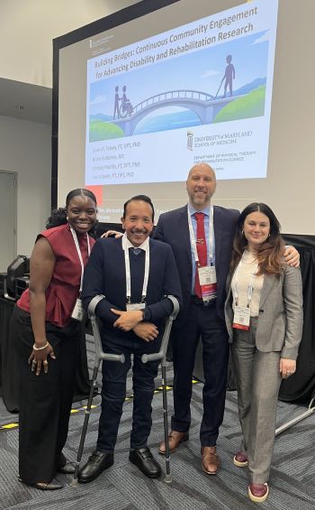 A picture of Lindsey Mathis, Brian Gutierrez, Jason Falvey, and Laura Baehr  in front of their projected presentation slides.