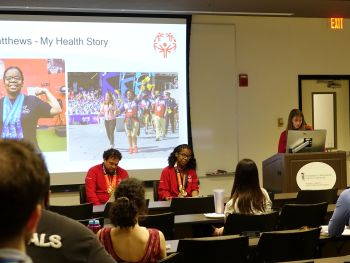 Two Special Olympics Maryland Athletes sitting at the front of a room presenting to a group.